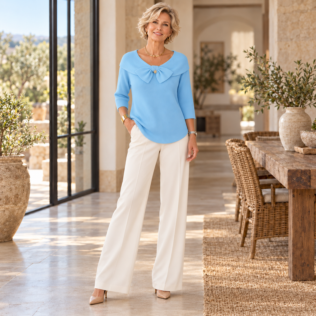 Tivella™ | Sweater with Bow and Round Neckline worn by a mature blonde woman in a sunlit Mediterranean home
